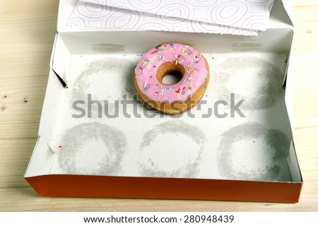 empty cakes box with only one tempting and delicious donut with toppings left in unhealthy nutrition and sugar and sweet cake addiction concept
