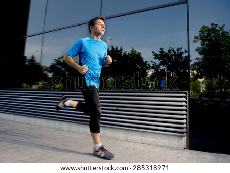 young attractive man running and training on urban street background on summer workout in sport practice and healthy lifestyle concept