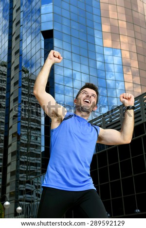 young attractive sport man doing victory and winner sign with his arms after running training in urban business district area in fitness, body care and healthy lifestyle concept