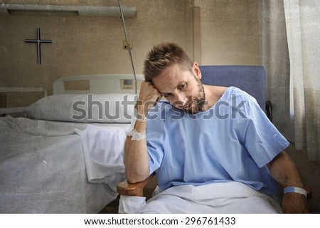 young injured man in hospital room sitting alone in pain looking negative and worried for his bad health condition sitting on chair suffering depression on a sad lonely medical background