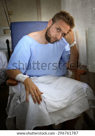 young injured man in hospital room sitting alone in pain looking negative and worried for his bad health condition sitting on chair suffering depression on a sad lonely medical background