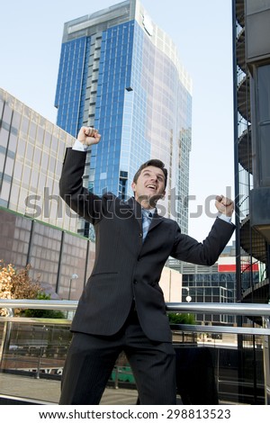 young attractive and successful businessman in suit and necktie happy and excited doing victory sign after reaching business goal outdoors on financial district street