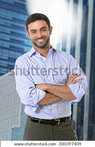 young attractive business man posing happy in corporate portrait outdoors on financial district background smiling with folded arms wearing casual businessman clothes in success concept