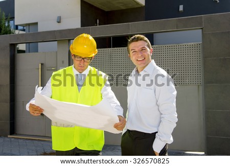 happy customer smiling and constructor foreman worker with helmet and vest  talking outdoors on new house building blueprints in real state business and housing industry concept