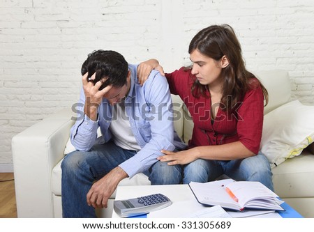 young couple worried home in stress wife comforting husband accounting debt unpaid bills bank papers expenses and pending payments feeling desperate in bad financial situation