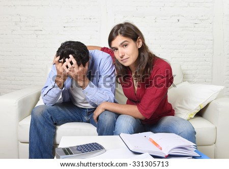 young couple worried home in stress wife comforting husband accounting debt unpaid bills bank papers expenses and pending payments feeling desperate in bad financial situation