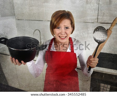 young attractive rookie home cook woman in red apron at home kitchen holding cooking pan and rolling pin crying sad in stress confused and helpless in lifestyle and cooking mess