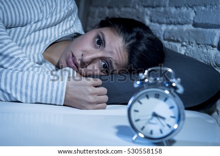 young beautiful hispanic woman at home bedroom lying in bed late at night trying to sleep suffering insomnia sleeping disorder or scared on nightmares looking sad worried and stressed