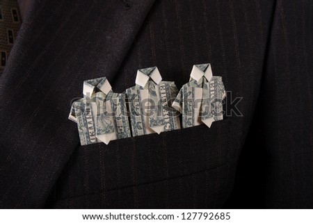 businessman with one dollar bill folded origami into a t-shirt in suit pocket