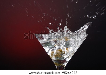 an olive splashing into a martini