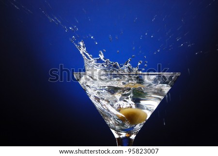 an olive splashing into a martini