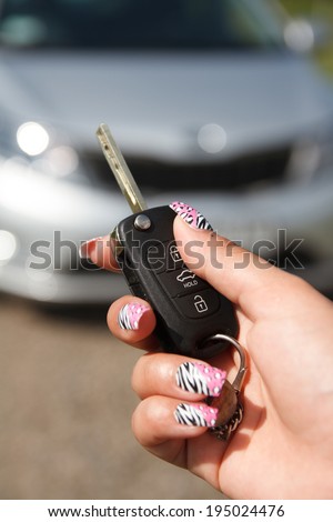 girl hand presses on the remote control car alarm systems