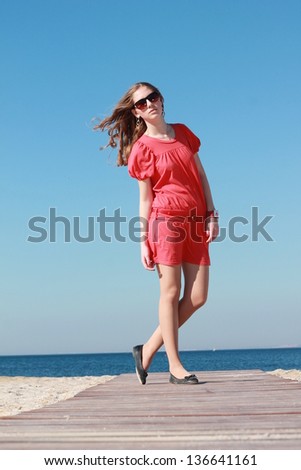Fashion outdoor portrait of young girl in a summer style by the sea