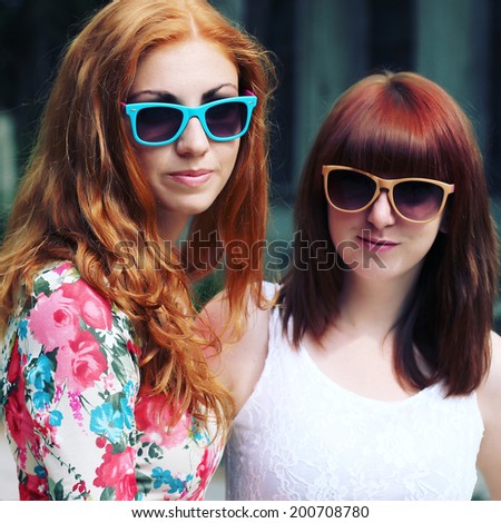 Two young happy girlfriends in sunglasses having fun. Lifestyle. Photo toned style instagram filters