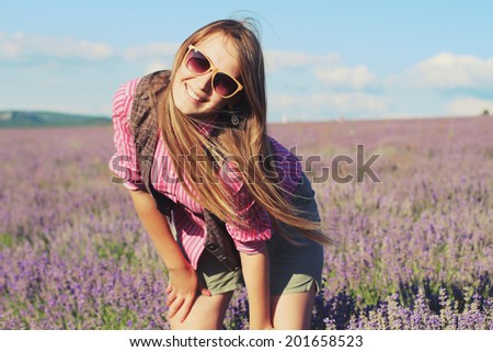 Young pretty woman posing outdoor in the lavender fields. Bohemian style. Blowing long hair. Fashion shooting. Boho-chic. Photo toned style Instagram filters
