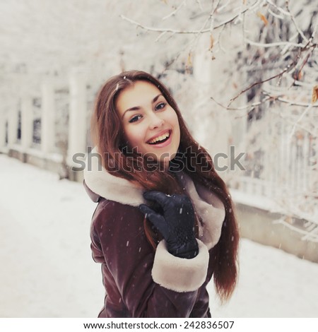 Portrait of young pretty funny smiling girl in cold weather dressed in color clothes and warm hat. Young happy woman having fun outdoor. Photo toned style Instagram filters.