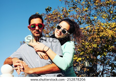 Holidays, vacation, love and friendship concept - smiling fashion couple having fun outdoors. Man with girl in spring urban style.