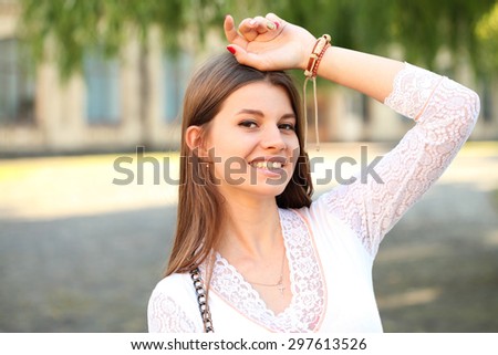 Beauty woman with perfect smile and white teeth walking on the street and looking at camera