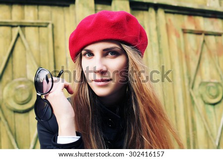 Elegant young Parisian woman outdoors. Beautiful charming girl in red beret. French Style