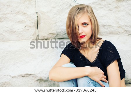 Fashion lifestyle portrait of young happy pretty blonde woman with red lips, bob hair laughing and having fun on the street at nice sunny day, wearing stylish vintage outfit, bright fresh colors.