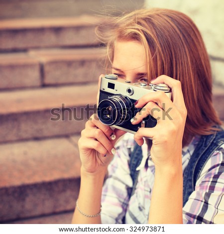 Portrait of young hipster girl making photo with vintage camera. Modern youth lifestyle concept. Lovely face. Photo toned style instagram filters