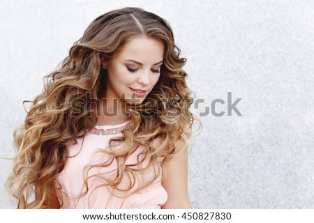 Beautiful young girl at the prom with gorgeous long curly hair . Professional make-up and hairstyle , stylish woman .