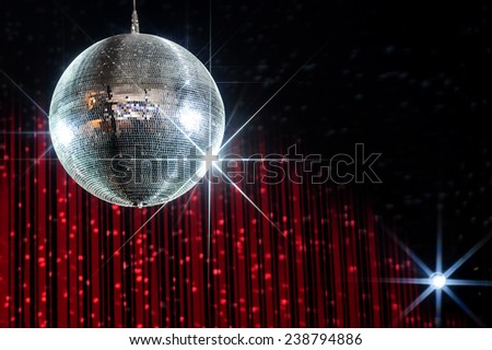 Disco ball with stars in nightclub with striped red and black walls lit by spotlight