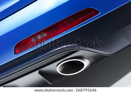 Chrome exhaust pipe of blue powerful racing car bumper with red back lighting