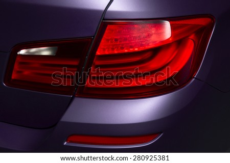 Car rear lights with matte surface, red backlights of lilac powerful sport sedan bodywork, concept