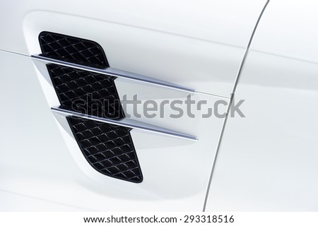 White sport car bodywork, metallic surface of racing vehicle, concept of aerodynamic high speed transport body, detail of door, wing and air intake