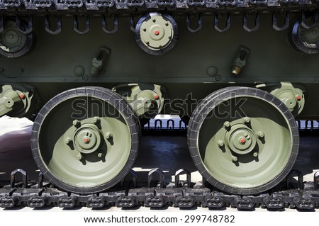 Tank caterpillar track and steel wheels of green color, military industry, modern army equipment, side view