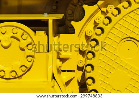 Caterpillar drive gear, bulldozer sprocket mechanism, large construction machine with bolts and yellow paint coating, heavy industry, detail