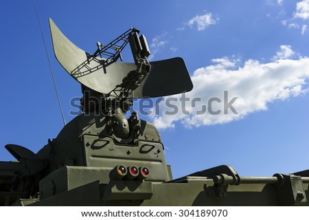 Air defense radar of military mobile mighty rocket launcher system of green color, modern army industry, white cloud and blue sky on background