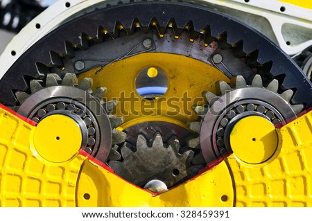 Drive gear and bearings, bulldozer sprocket internal mechanism, large construction machine with bolts and yellow paint coating, heavy industry, detail