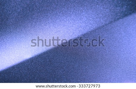 Fragment of blue steel car bodywork, vehicle silver paint coating texture, selective focus, abstract
