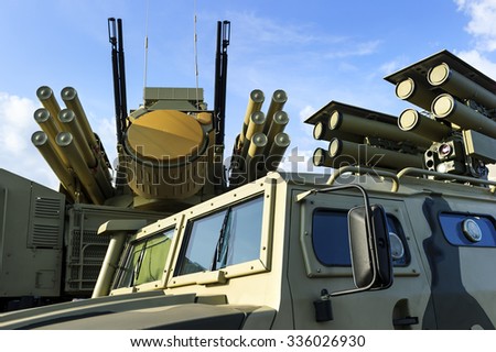 Military offroader vehicle with anti-tank guided missile system, multifunction weapon complex with rocket launcher, heavy machine gun and mobile antiaircraft radar on background