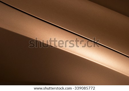 Surface of bronze sport sedan car, detail of metal hood, fender and door of vehicle bodywork