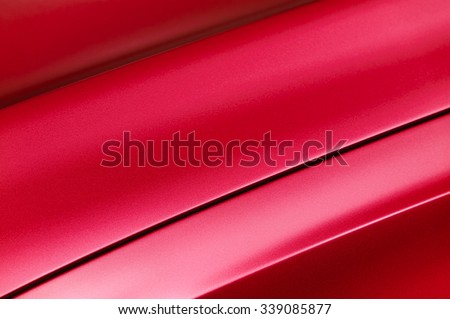 Fragment of red steel car bodywork, vehicle silver paint coating texture, selective focus, abstract