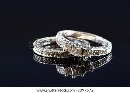stock photo Engagement ring and wedding band on black background with 