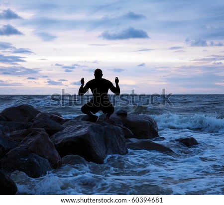 Man meditating on a stony sea shore