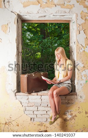 Young reads a book in abandoned building