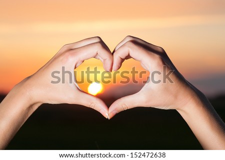 Heart shaped hands with sunrise