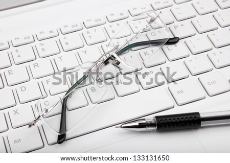 Computer keyboard glasses and pen (to express the concept of long working hours)