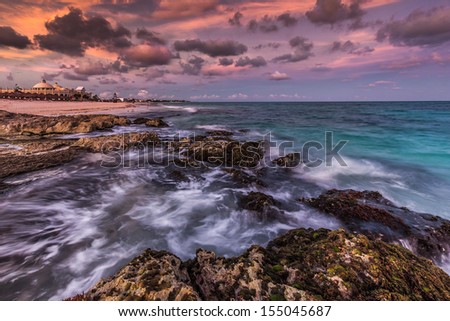RIVIERA MAYA, MEXICO - FEBRUARY 20: Purple sunset over a tropical rocky beach on February 20, 2012 in Riviera Maya, Mexico.