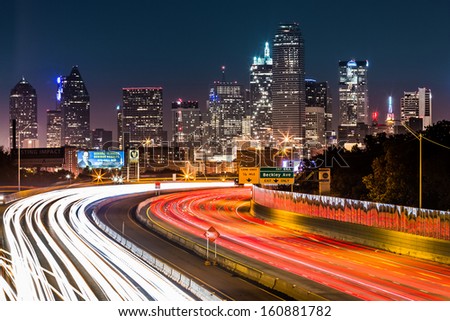Dallas, Usa - October 25: Dallas Skyline By Night On October 25, 2013 In Dallas, Usa. The Rush Hour Traffic Leaves Light Trails On I-30 (Tom Landry) Freeway.