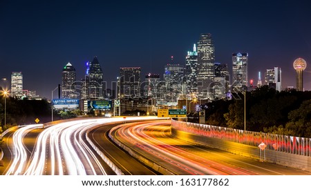 DALLAS, USA - OCTOBER 25: Dallas skyline by night on October 25, 2013 in Dallas, USA. The rush hour traffic leaves light trails on I-30 (Tom Landry) freeway.