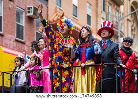 NEW YORK - FEBRUARY 2, 2014:  Young man dressed in a clown costume salutes the crowd at the Lunar New Year Festival in Chinatown. Next to him parade young girls dressed as princesses.