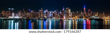 New York midtown panorama by night, taken in front of the 42nd street canyon. The Empire State Building displays the colors of the American flag to honor the Presidents\' Day.