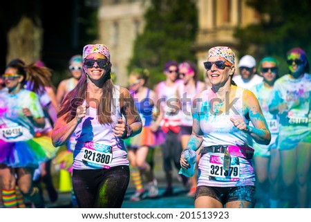 MORRISTOWN, NJ, USA - JUNE 6, 2014: Women couple runs the Color Vibe 5K race. Color Vibe is a fun un-timed event with no winners or prizes where runners are showered with colored powder along the run.