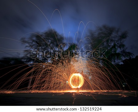 Fire spinning from steel wool . 30 seconds exposure time